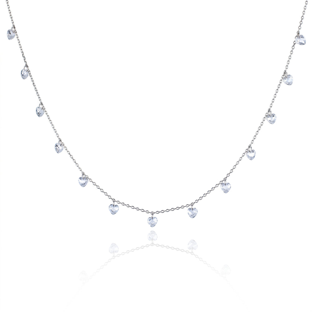 A delicate silver-toned necklace featuring a series of small, dangling heart-shaped clear gemstones along a fine chain, presented on a clean white background with a soft reflection below.