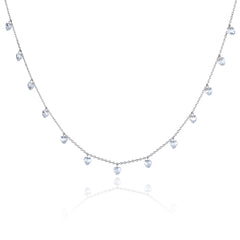 A delicate silver-toned necklace featuring a series of small, dangling heart-shaped clear gemstones along a fine chain, presented on a clean white background with a soft reflection below.