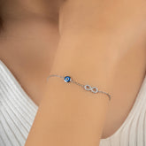 Silver bracelet with a blue eye charm on a person's wrist