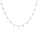 A delicate silver-toned necklace featuring a series of small, dangling heart-shaped clear gemstones along a fine chain, presented on a clean white background with a soft reflection below.
