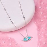 Necklace with a blue eye pendant on a pink background