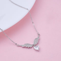 Pure Silver necklace with a heart pendant and angel wings on a pink background
