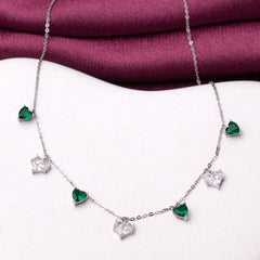 925 silver Necklace with heart-shaped emerald and diamond pendants on a white surface with a purple fabric background