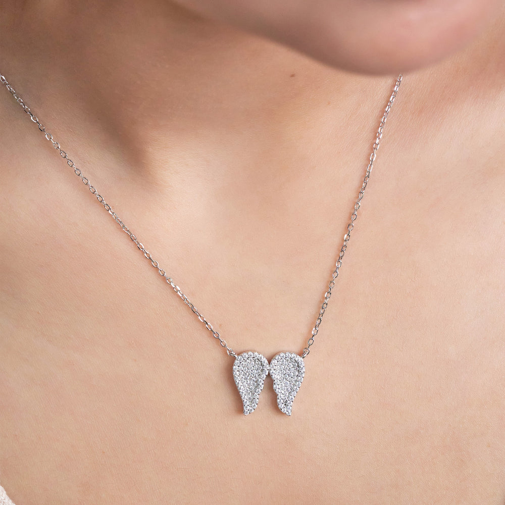 Pure Silver necklace with angel wing pendants on a person's neck