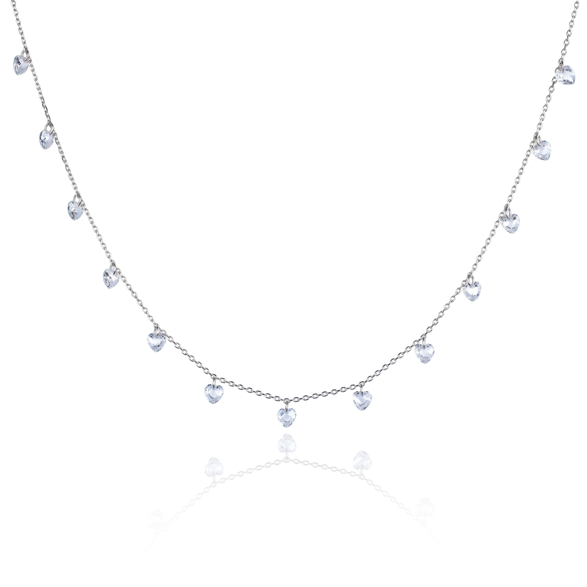 A delicate silver-toned necklace featuring a series of small, dangling heart-shaped clear gemstones along a fine chain, presented on a clean white background with a soft reflection below.