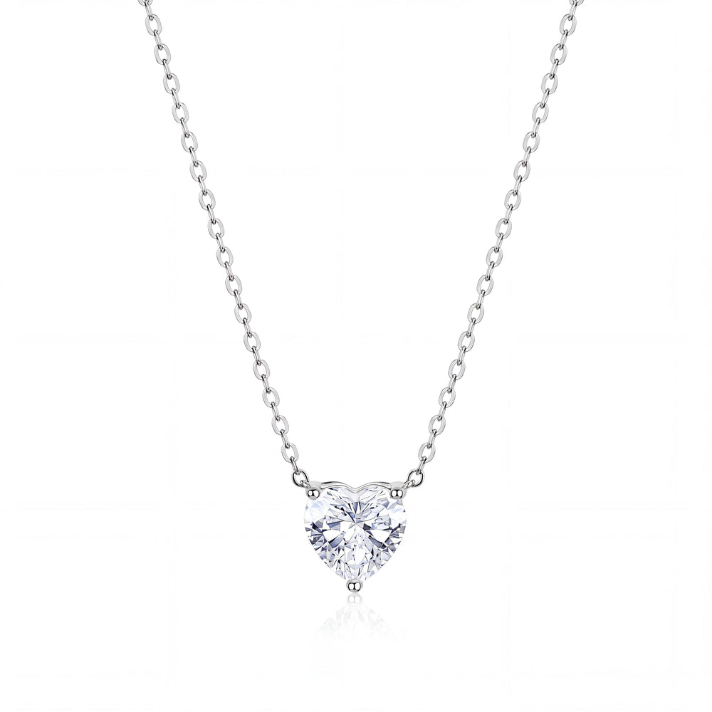 A heart-shaped diamond pendant necklace in a solitaire setting on a delicate silver chain, presented on a clean white background with a subtle reflection.