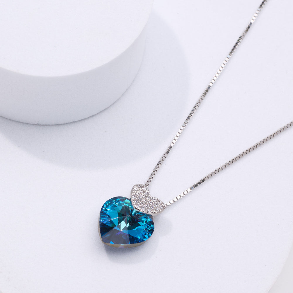 pure silver Necklace with a blue heart-shaped crystal pendant on a white background