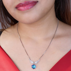 925 Crystal Silver Necklace with a blue pendant worn by a person in a red top
