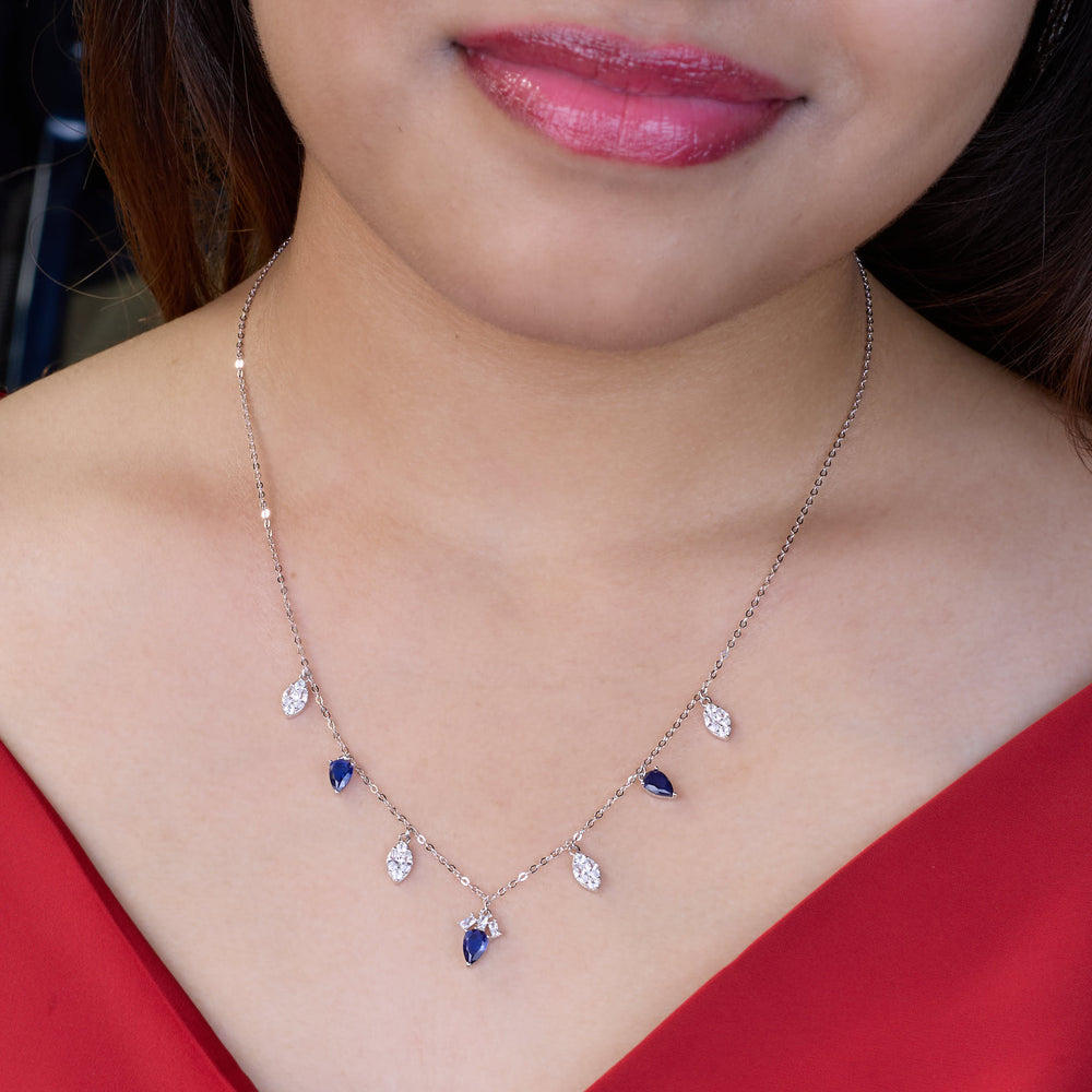 925 silver Necklace with blue and clear stones worn by a person in a red top.