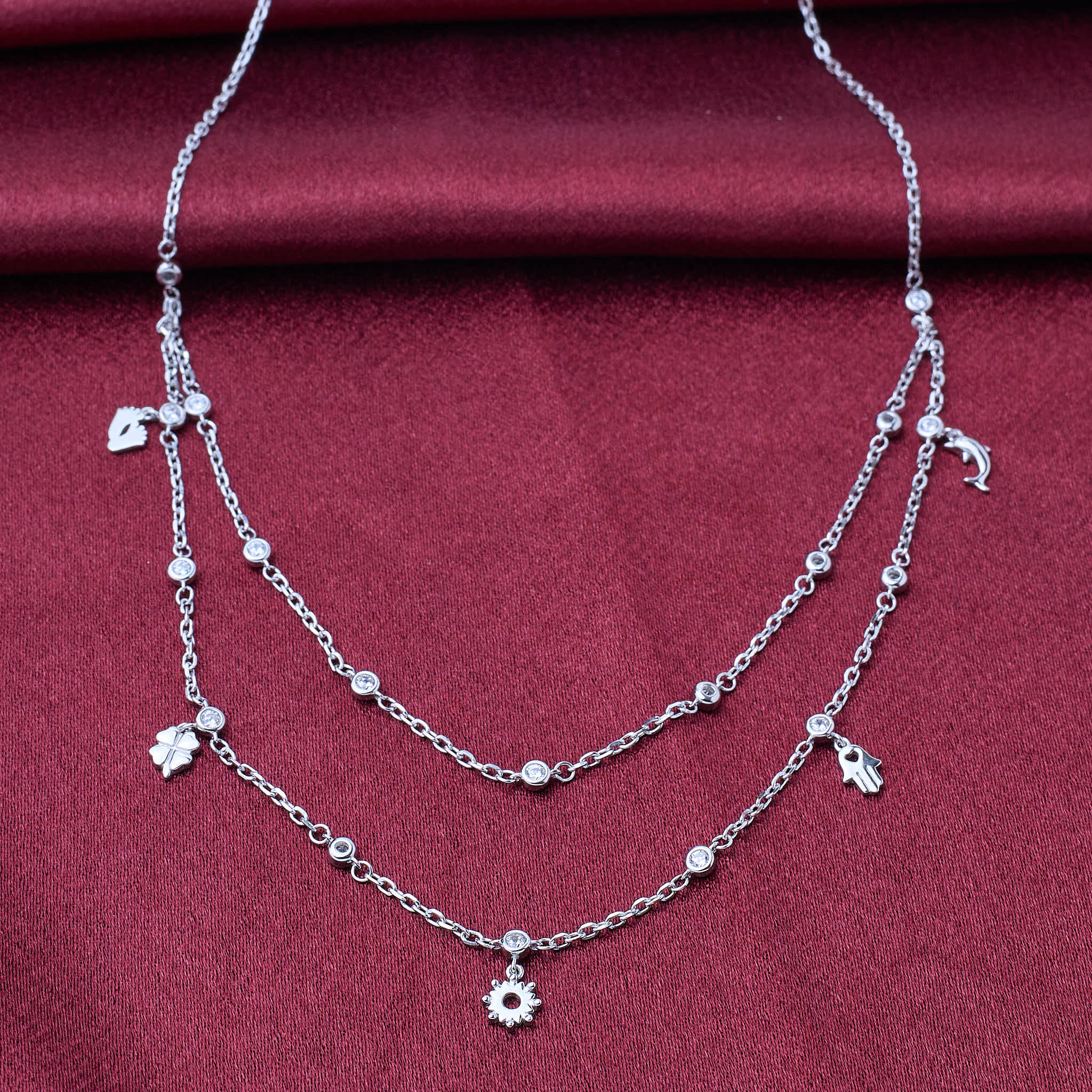 925 silver Silver necklace with floral charms on a red fabric background