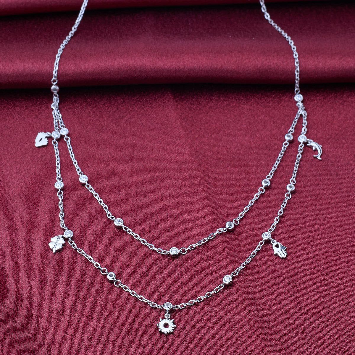 925 silver Silver necklace with floral charms on a red fabric background