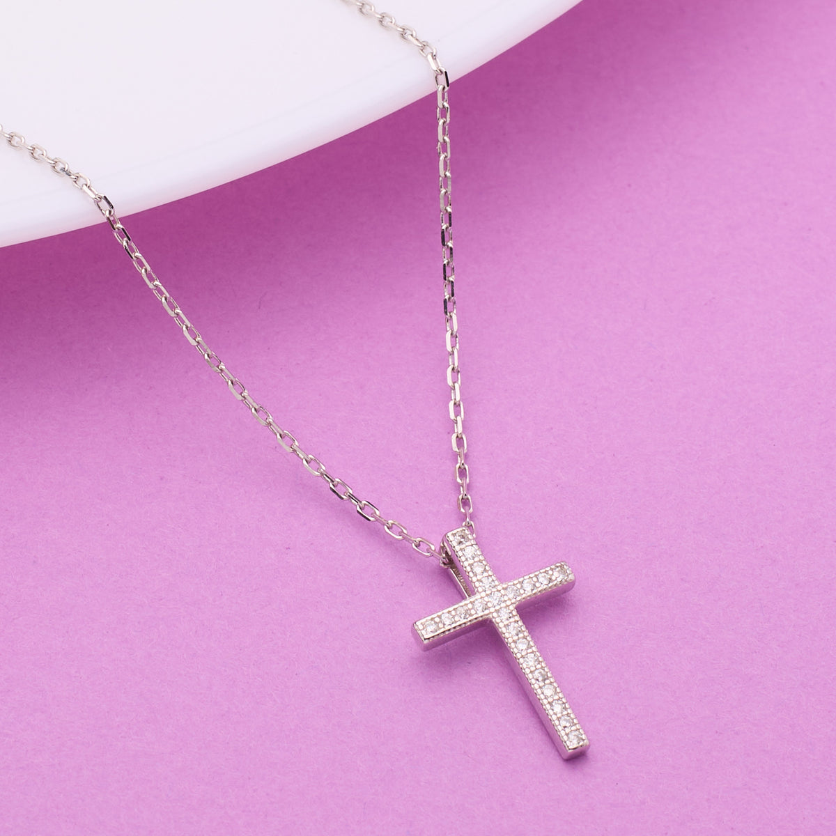 925 Silver cross necklace on a pink background