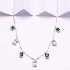 Silver necklace with green gemstones on a white background