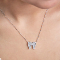 Pure Silver necklace with angel wing pendants on a person's neck